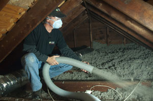 Contractor blowing cellulose insulation into attic